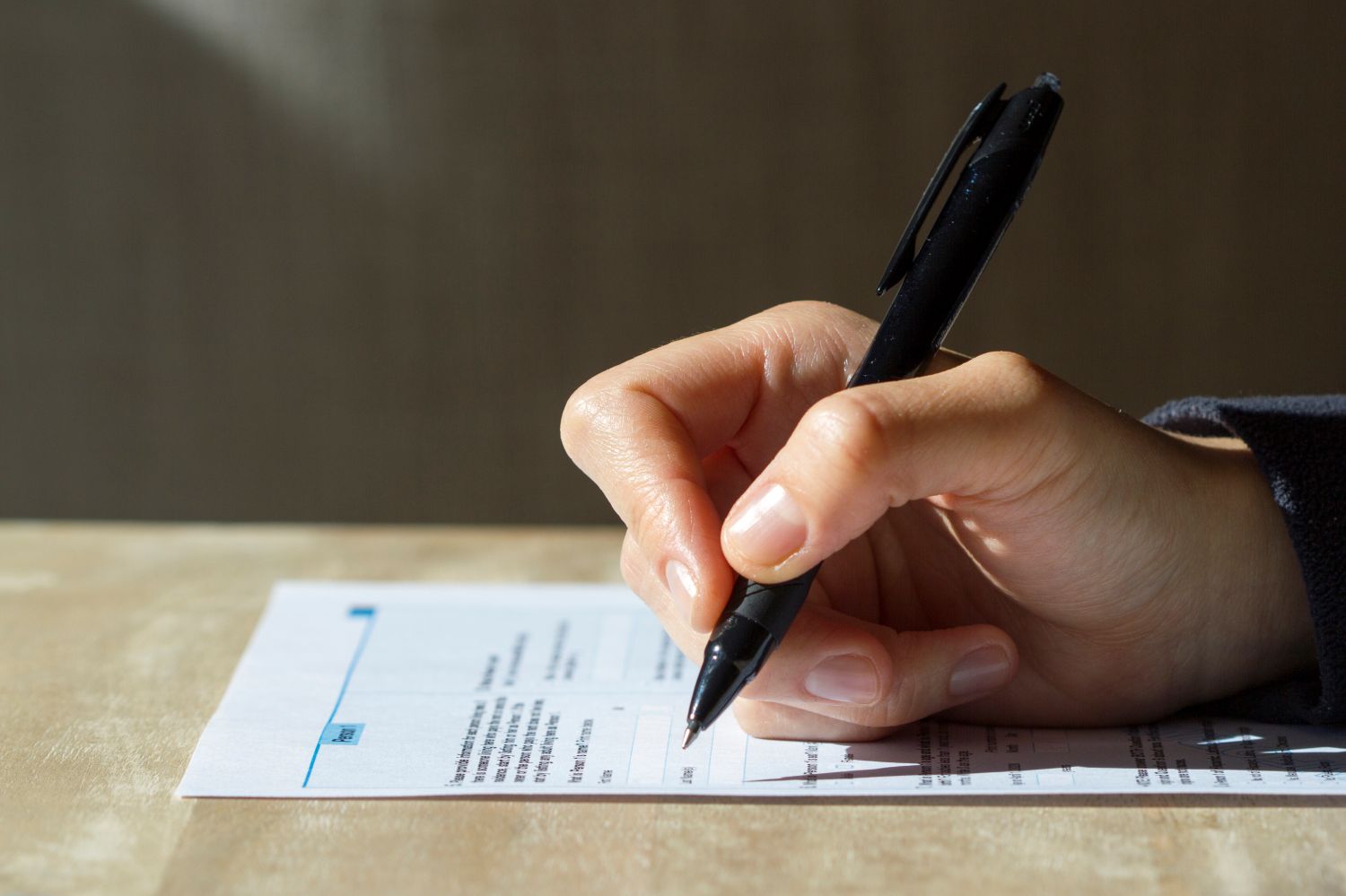 Person writing with a pen image