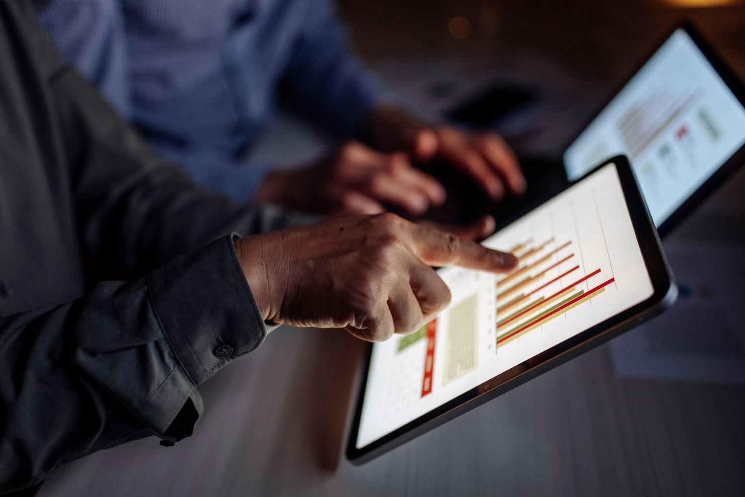 Office professionals using a pad device showing charts image